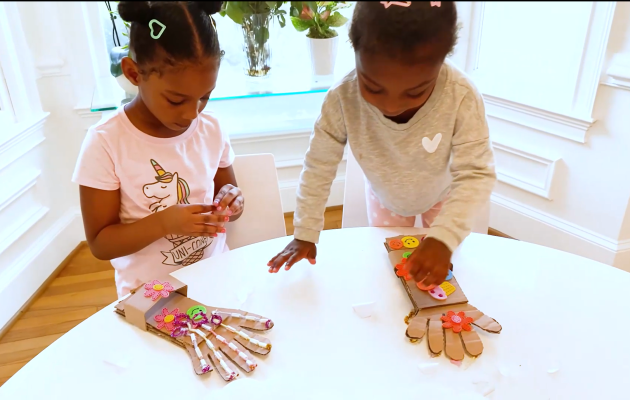 Nalah and Nadia make cardboard robot hands.